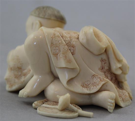 A Japanese carved ivory okimono of a child with a spinning top, 19th century, 17.6cm